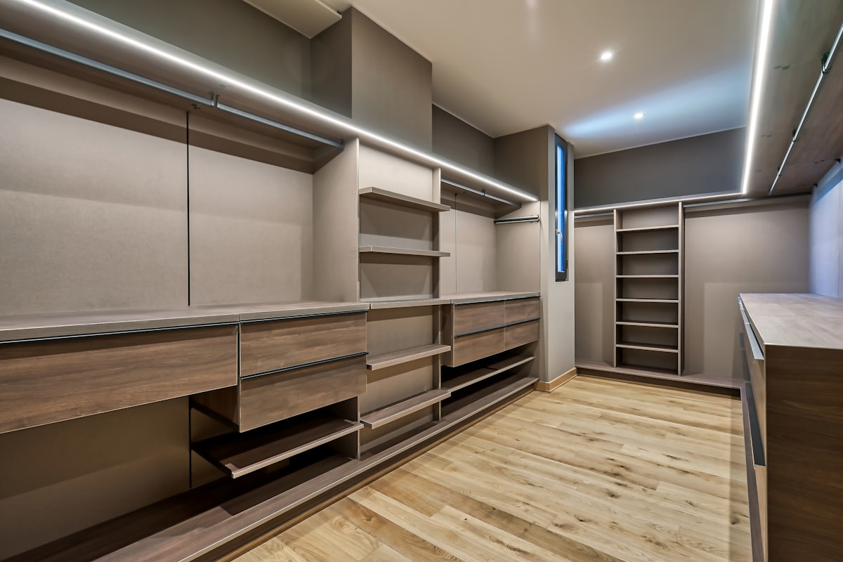 A walk-in wardrobe with open shelving, hanging rails and drawer banks